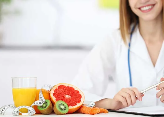 Doctor beside collection of fruit and glass of orange juice